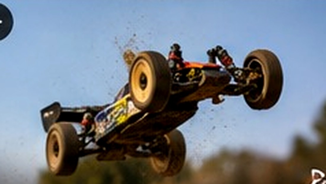 RC buggy airborne over an outdoor dirt jump